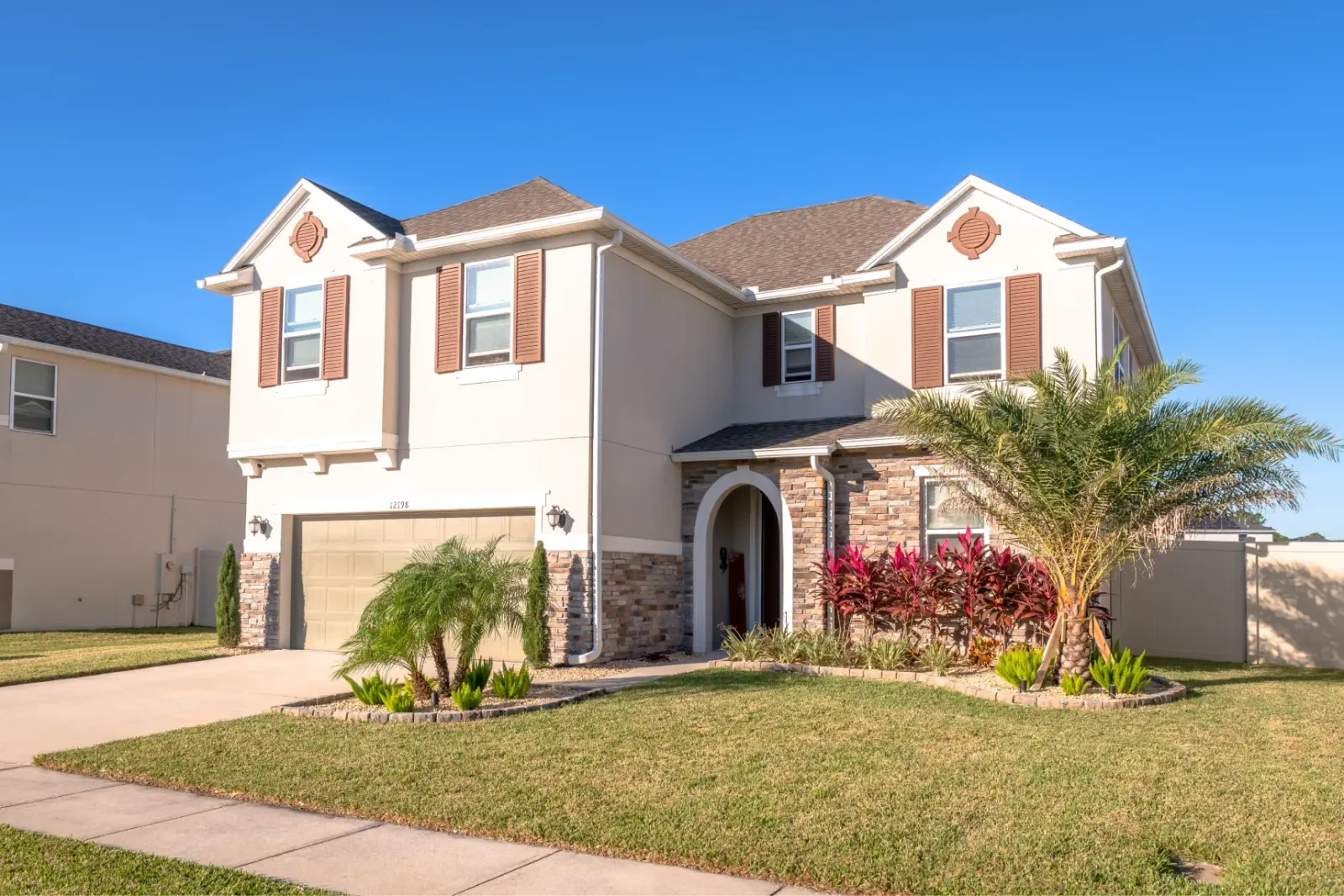 Spacious two-story home with a well-manicured lawn and bright exterior.