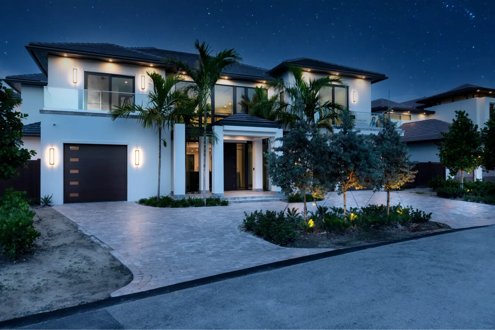 Luxurious two-story home with modern architecture and elegant landscaping under a starry night sky.