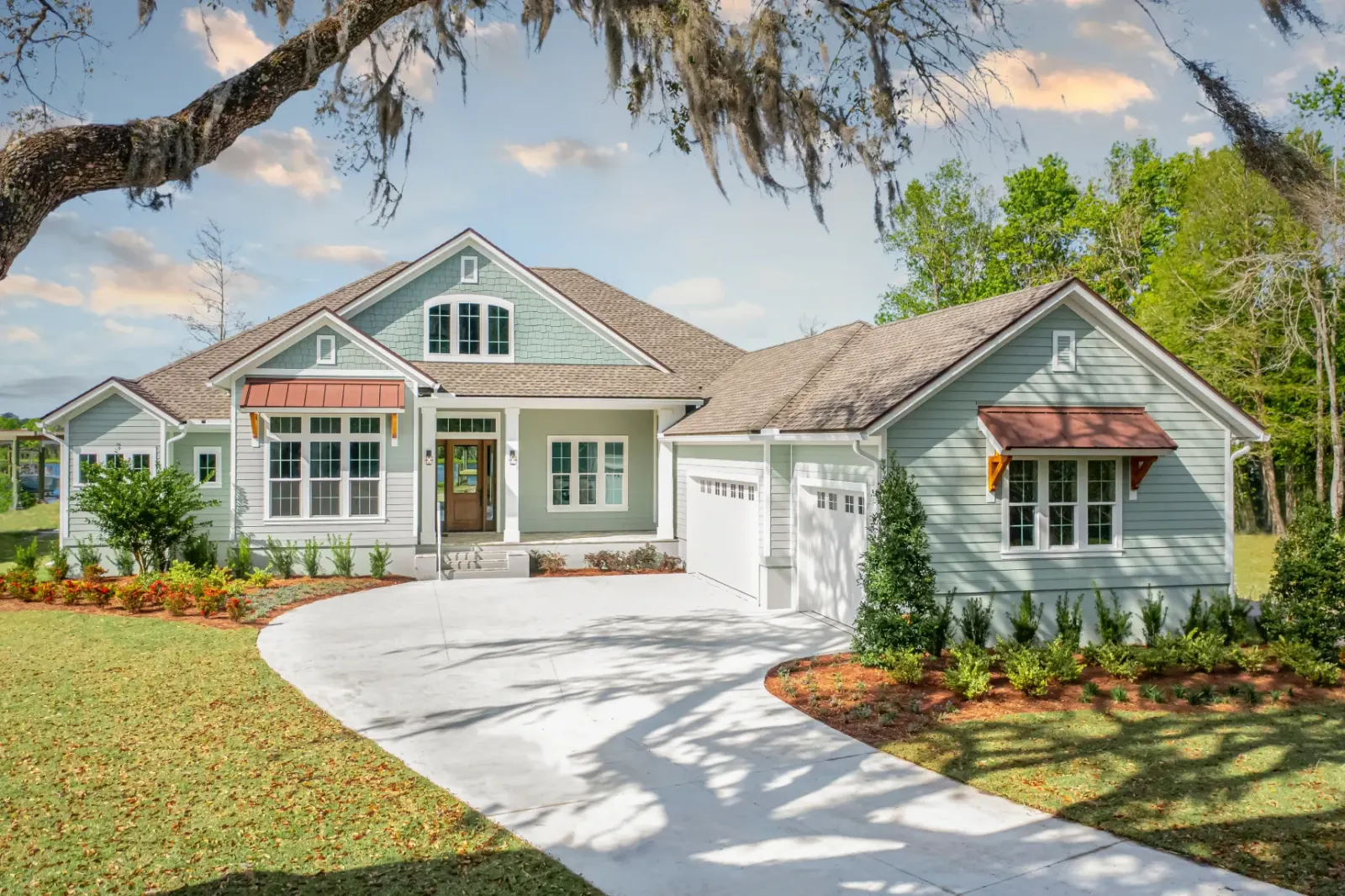 Modern farmhouse-style home with circular driveway and well-maintained landscape.