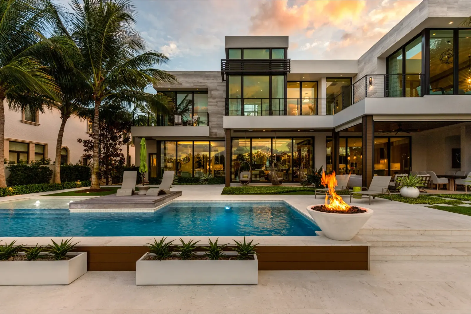 Modern home with a pool and fire pit.